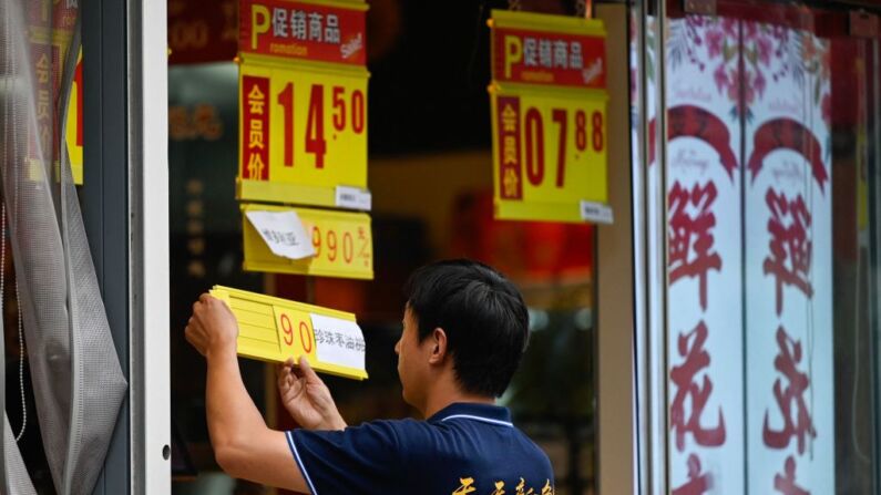 Un vendedor de frutas y verduras actualiza el precio de un artículo en un mercado de Beijing, el 9 de agosto de 2023. (PEDRO PARDO/AFP vía Getty Images)
