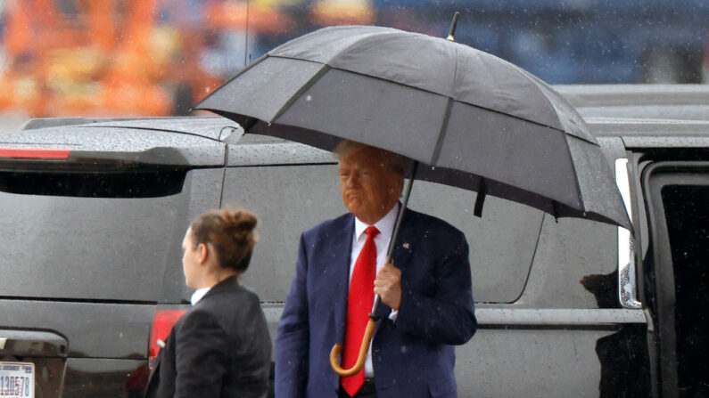 El expresidente de Estados Unidos Donald Trump sostiene un paraguas mientras llega al Aeropuerto Nacional Reagan después de comparecer y declararse inocente por cargos federales sobre las elecciones de 2020, ante una corte de Washington, D.C. el 3 de agosto de 2023 en Arlington, Virginia. (Tasos Katopodis/Getty Images)