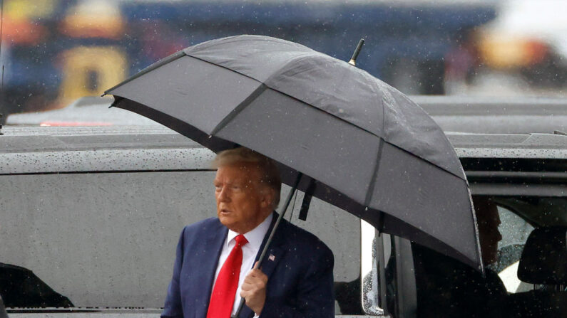 El expresidente de Estados Unidos, Donald Trump, sostiene un paraguas mientras llega al Aeropuerto Nacional Reagan después de comparecer a una lectura de cargos en una corte de Washington, en Arlington, Virginia, el 3 de agosto de 2023. (Tasos Katopodis/Getty Images)