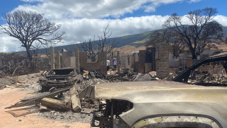 Residentes caminan entre sus casas destruidas tras un incendio forestal en Lahaina, al oeste de Maui, Hawái, el 11 de agosto de 2023. (PAULA RAMON/AFP vía Getty Images)