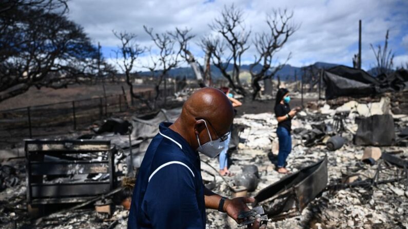 Hano Ganer busca pertenencias entre las cenizas de la casa de su familia el 11 de agosto de de 2023, tras un incendio forestal que redujo a escombros la ciudad de Lahaina, al oeste de Maui, Hawái. (Patrick T. Fallon/AFP vía Getty Images)