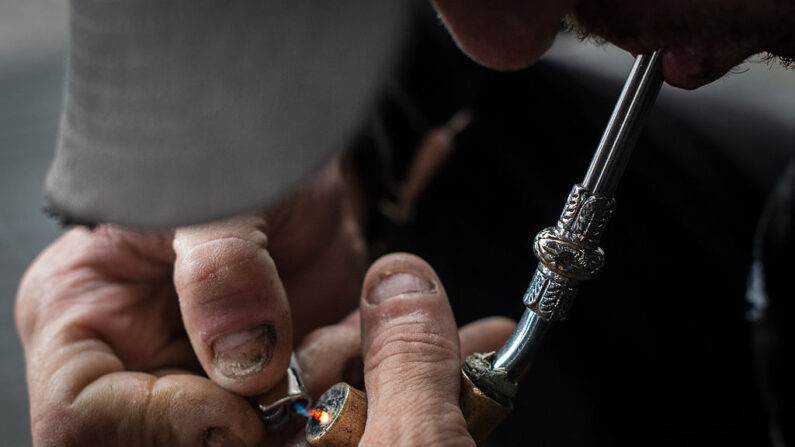 Un drogadicto enciende una pipa improvisada en "Crackolandia", un lugar donde los drogadictos se reúnen para fumar crack, en el centro de Sao Paulo, Brasil el 11 de enero de 2013. (Yasuyoshi Chiba/AFP vía Getty Images)