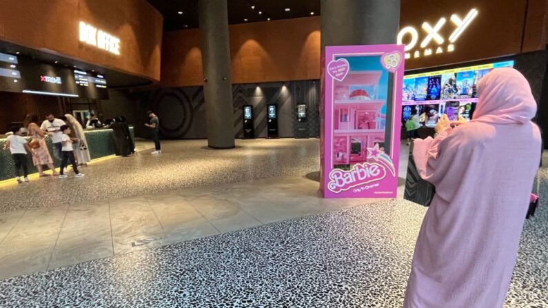 Una mujer vestida de rosa a la entrada de un cine donde se proyecta la película "Barbie", en Dubái, el 14 de agosto de 2023. (Giuseppe Cacace/AFP vía Getty Images)