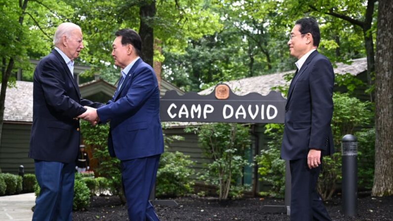 El presidente de los Estados Unidos, Joe Biden (izquierda), da la bienvenida al presidente de Corea del Sur, Yoon Suk Yeol (centro), y al primer ministro japonés, Fumio Kishida, a Camp David, Maryland, para una cumbre trilateral el 18 de agosto de 2023. (Jim Watson/ AFP vía Getty Images)