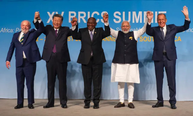 (De izq. a dcha.): El presidente de Brasil, Luiz Inácio Lula da Silva, el líder de China, Xi Jinping, el presidente de Sudáfrica, Cyril Ramaphosa, el primer ministro de India, Narendra Modi, y el ministro de Asuntos Exteriores de Rusia, Sergei Lavrov, levantan los brazos mientras posan para una fotografía de grupo en la Cumbre de los BRICS en Johannesburgo, Sudáfrica, el 23 de agosto de 2023. (Alet Pretorius/Pool/AFP vía Getty Images)