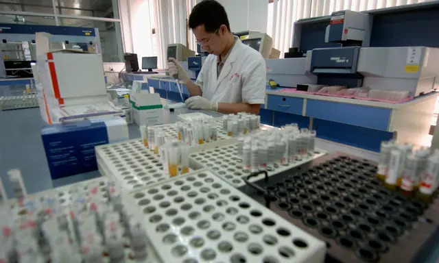 Un trabajador de inspección analiza muestras de sangre de donantes voluntarios en el Centro de Sangre de Guangzhou, en Guangzhou, provincia china de Guangdong, el 13 de junio de 2005. (China Photos/Getty Images)