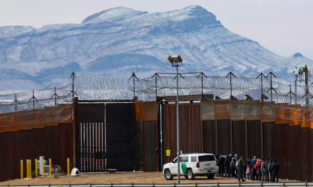 Agentes de la Patrulla Fronteriza detienen a un grupo de migrantes cerca del muro fronterizo, después de que entraran en Estados Unidos desde Ciudad Juárez, estado de Chihuahua, México, frontera con El Paso, Texas, el 3 de febrero de 2022. (Herika Martinez/AFP vía Getty Images)
