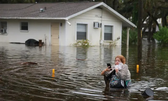 Makatla Ritchter vadea las aguas de la inundación tras tener que evacuar su casa cuando las aguas del huracán Idalia la inundaron el 30 de agosto de 2023 en Tarpon Springs, Florida. (Joe Raedle/Getty Images)