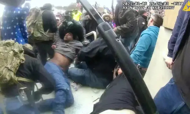 El manifestante Philip Anderson es sacado de debajo de un montón de cadáveres en la boca del túnel de Lower West Terrace el 6 de enero de 2021. (Departamento de Policía Metropolitana / Captura de pantalla vía The Epoch Times)