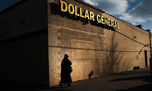 Una mujer camina junto a una tienda Dollar General el 11 de diciembre de 2018 en el barrio de Brooklyn de Nueva York.