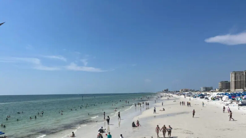 Turistas y lugareños juegan en las olas y la arena en Clearwater Beach, Florida, el 2 de julio de 2023. (Nanette Holt/The Epoch Times)
