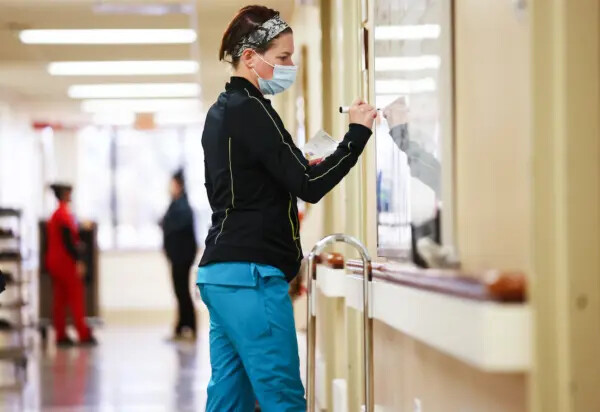 Una empleada de la salud toma notas en el tablero de asignaciones en una unidad que alguna vez tuvo numerosos pacientes con COVID-19, en el Centro Médico Providence St. Mary, en Apple Valley, California, el 11 de marzo de 2022. (Mario Tama/Getty Images)

