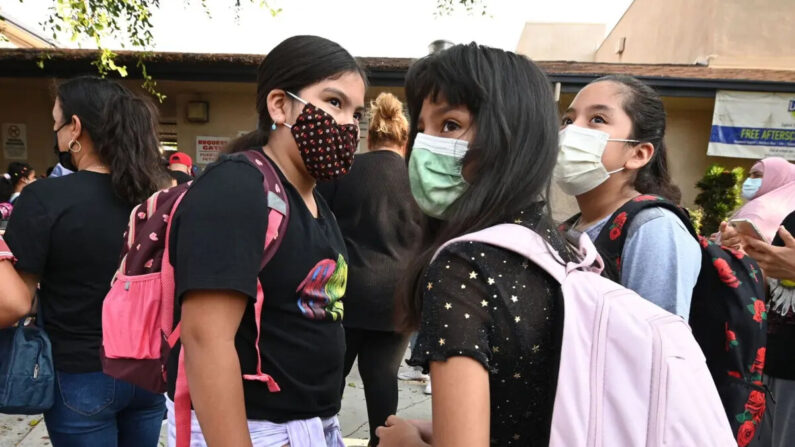 Los estudiantes y sus padres llegan con mascarillas el primer día del año escolar a la Escuela Primaria Grant, en Los Ángeles, California, el 16 de agosto de 2021. (Robyn Beck/AFP vía Getty Images)