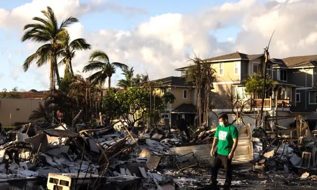 Un voluntario evalúa los daños de un complejo de apartamentos calcinados después de un incendio forestal en Lahaina, en el oeste de Maui, Hawái, el 12 de agosto de 2023. (Yuki Iwamura/AFP vía Getty Images)
