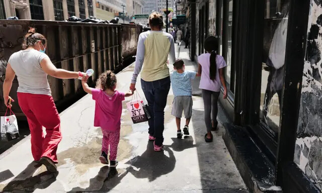 Inmigrantes ilegales recién llegados se reúnen afuera del Hotel Roosevelt, en la ciudad de Nueva York, el 14 de agosto de 2023. (Spencer Platt/Getty Images)
