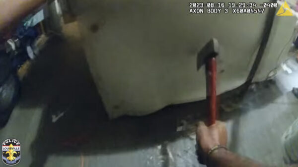 Una captura de pantalla de la grabación de la cámara de vigilancia muestra a un agente utilizando un hacha para cortar la cadena del suelo (Cortesía del Departamento de Policía de Louisville).