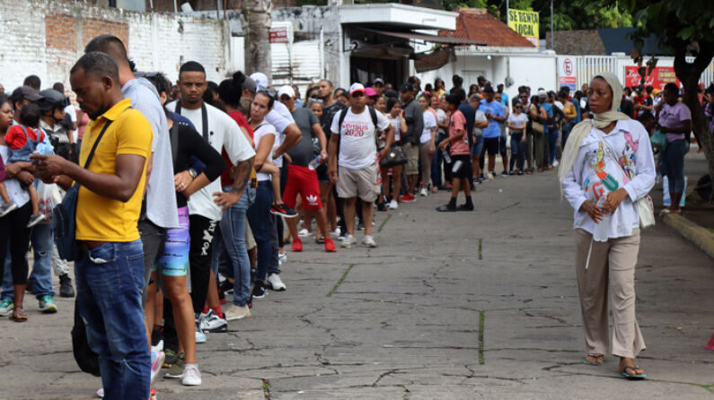 Migrantes hacen fila en espera de regularizar su documentación, el 14 de septiembre de 2023, en el municipio de Tapachula, en el estado de Chiapas, México. La Comisión Mexicana de Ayuda a Refugiados (COMAR) reporta un incremento interanual del 30 % enero a agosto del 2023, cuando registró casi 100,000 solicitantes, una situación que mantiene saturada la frontera sur. (EFE/Juan Manuel Blanco)