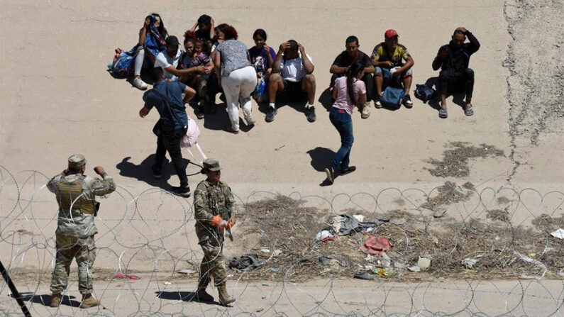 Fotografía de archivo de un grupo de migrantes que permanece a un costado de la frontera con Estados Unidos vigilada por personal de la Guardia Nacional, en Ciudad Juárez, Chihuahua (México). EFE/Luis Torres