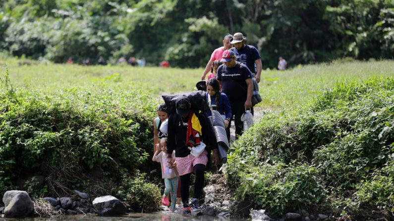 Fotografía de archivo fechada el 18 de agosto de 2023 donde aparecen unos migrantes acompañados con niños pequeños mientras caminan en el sector de Cañas Blancas en Darién (Panamá). EFE/Carlos Lemos