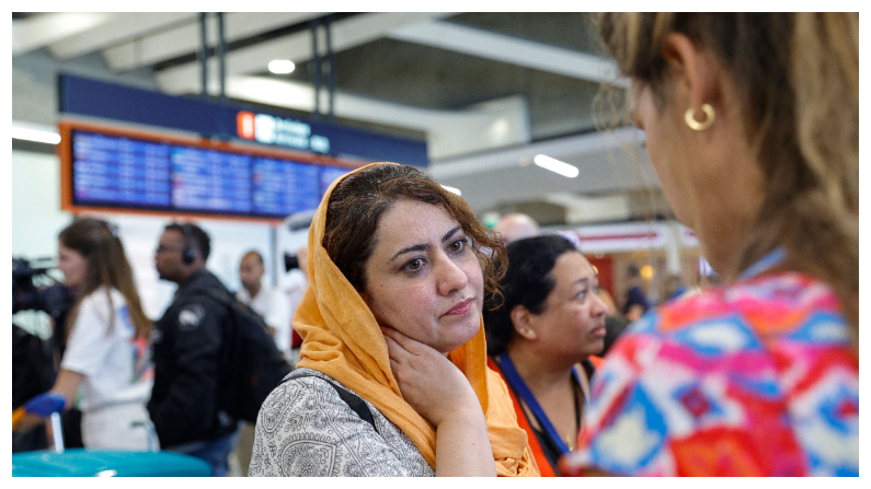 La investigadora y activista por los derechos de las mujeres, Naveen Hashim (I) habla con un periodista documentalista a su llegada junto a otras cuatro mujeres afganas y tres niños al aeropuerto Roissy-Charles de Gaulle en Roissy, al norte de la capital francesa, tras su evacuación de Pakistán después de huir de los talibanes y exiliarse en Pakistán hace meses, el 4 de septiembre del 2023. (Foto de GEOFFROY VAN DER HASSELT/AFP vía Getty Images)