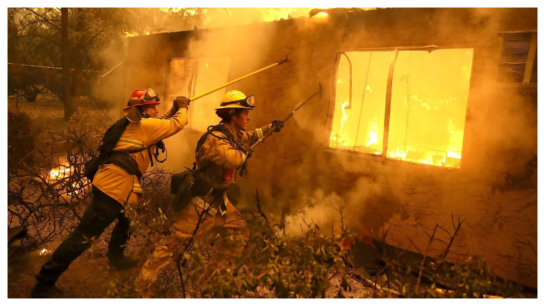 Los bomberos intentan evitar que las llamas de una casa en llamas se propaguen a un complejo de apartamentos vecino mientras luchan contra el Camp Fire en Paradise, California, el 9 de noviembre del 2018. (Justin Sullivan/Getty Images)