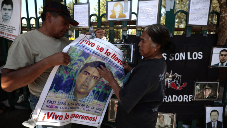 Padres de los 43 estudiantes desaparecidos de Ayotzinapa, acompañados por defensores de derechos humanos, protestan al término de una rueda de prensa hoy, frente al Campo Militar 1 en Ciudad de México.  (EFE/José Méndez)