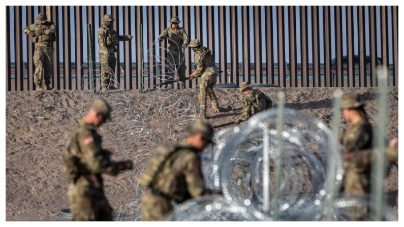 Soldados de la Guardia Nacional de Texas desenrollan alambre concertina cerca de la valla fronteriza entre Estados Unidos y México en El Paso, Texas, el 10 de mayo del 2023. (John Moore/Getty Images)