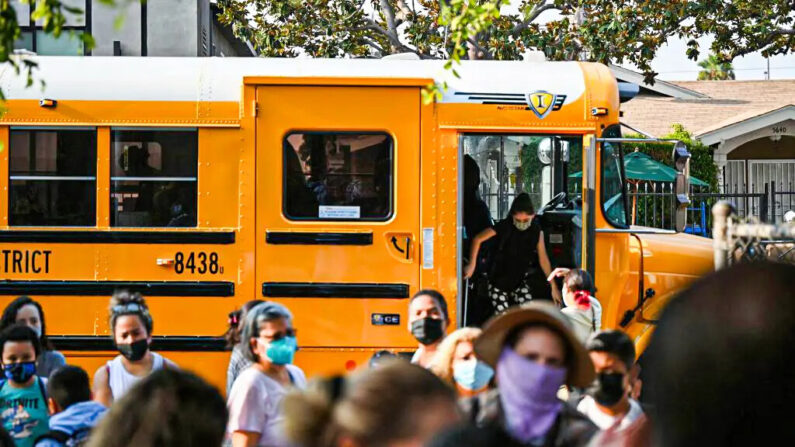 Estudiantes y padres llegan enmascarados para el primer día del año escolar en la Escuela Primaria Grant en Los Ángeles el 16 de agosto de 2021. (Robyn Beck/AFP vía Getty Images)