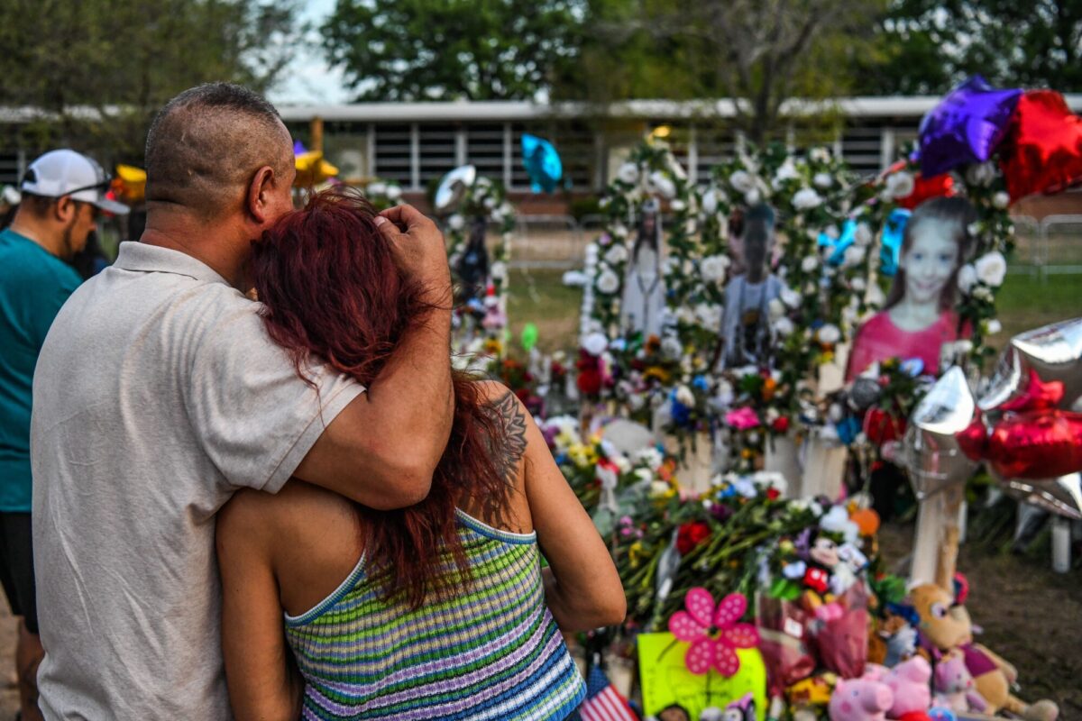 La gente rinde homenaje y llora en un monumento improvisado para las víctimas del tiroteo en la Escuela Primaria Robb en Uvalde, Texas, 31 de mayo de 2022. (Foto de CHANDAN KHANNA/AFP vía Getty Images)