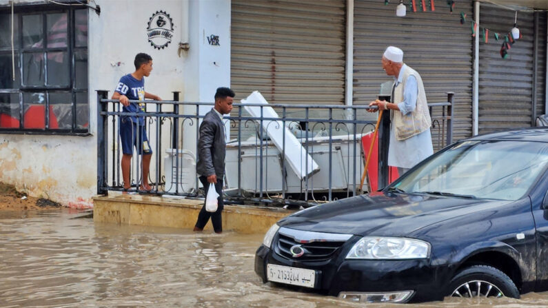 En una fotografía de archivo, libios vadean las aguas tras las fuertes lluvias caídas en Trípoli el 19 de octubre de 2022. (Mahmud Turkia/AFP vía Getty Images)