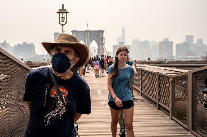 Una persona lleva una mascarilla en el puente de Brooklyn mientras el humo de los incendios forestales de Canadá cubre el Bajo Manhattan el 30 de junio de 2023 en Nueva York. (David Dee Delgado/Getty Images)