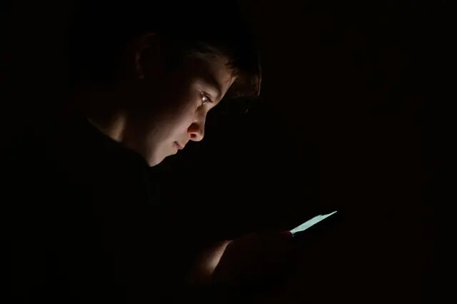 Un adolescente mira la pantalla de un teléfono móvil en Londres, el 17 de enero de 2023. (Leon Neal/Getty Images)
