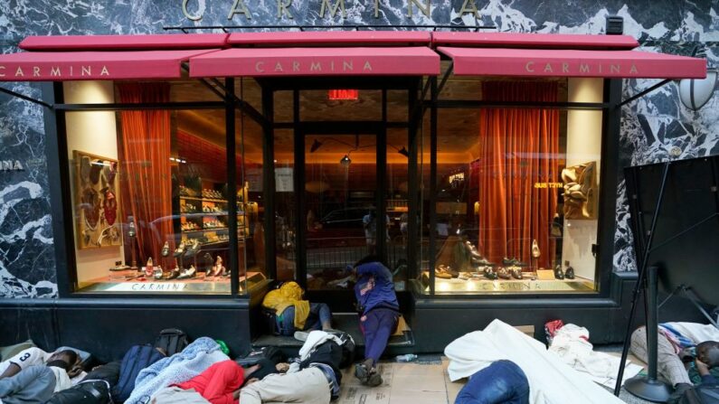 Inmigrantes ilegales duermen fuera del Hotel Roosevelt mientras esperan sean admitidos en el hotel en Nueva York el 1 de agosto de 2023. (TIMOTHY A. CLARY/AFP vía Getty Images)