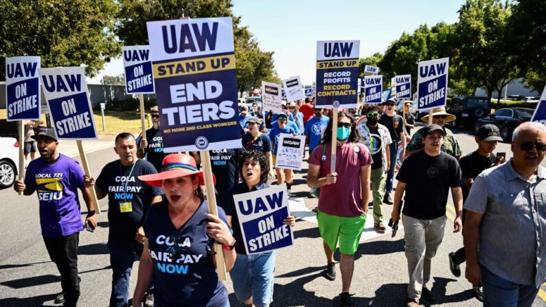 Simpatizantes y miembros del sindicato United Auto Workers (UAW) Local 230 marchan a lo largo de una línea de piquete durante una huelga fuera del Centro de Distribución de Piezas Stellantis Chrysler Los Angeles en Ontario, California, el 26 de septiembre de 2023. (Patrick T. Fallon/AFP vía Getty Images)