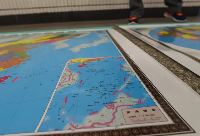 Un mapa diseñado por China incluye un inserto con nueve líneas discontinuas que muestran el territorio reclamado por el régimen chino en el mar de China Meridional en Pekín el 15 de junio de 2016. (Greg Baker/AFP vía Getty Images)