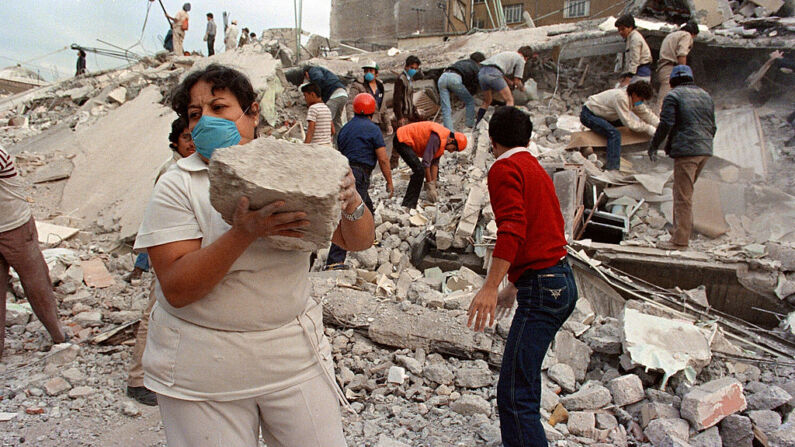 Rescatistas y voluntarios buscan entre los escombros de un edificio derrumbado en la Zona Rosa del entonces Distrito Federal, hoy Ciudad de México, una popular zona comercial y turística, el 21 de septiembre de 1985, después de que un terremoto arrasara gran parte de la ciudad el 19 de septiembre de 1985. (OMAR TORRES/AFP via Getty Images)