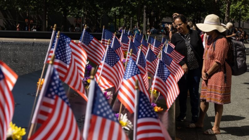 Visitantes observan banderas estadounidenses en el Monumento Conmemorativo del 9/11 en Nueva York, el 10 de septiembre de 2022, un día antes del 21 aniversario de los atentados contra el World Trade Center. (Yuki Iwamuri/AFP vía Getty Images)