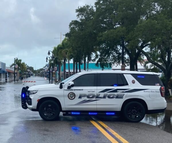 Un carro de policía en Tarpon Springs, Florida, impide a los automovilistas circular por Dodecanese Boulevard hacia el Sponge Docks Exchange el 30 de agosto del 2023 después de que el huracán Idalia pasara a 125 millas de la costa la noche anterior, enviando una marejada ciclónica que inundó gran parte de la zona. (John Haughey/The Epoch Times)