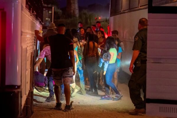 Agentes de la Patrulla Fronteriza escoltan a inmigrantes ilegales a un autobús para llevarlos a un centro de procesamiento en Eagle Pass, Texas, el 25 de junio del 2023. (Suzanne Cordeiro/AFP vía Getty Images)
