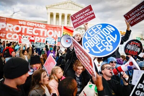 Activistas pro-vida y pro-aborto sostienen carteles con puntos de vista opuestos durante la 50ª manifestación anual Marcha por la Vida frente al Tribunal Supremo de EE.UU. en Washington el 20 de enero del 2023. (Chip Somodevilla/Getty Images)