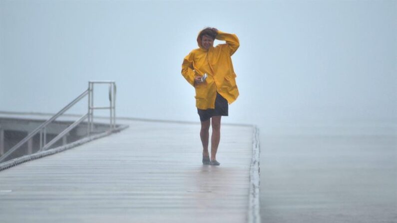 Una persona camina bajo una fuerte lluvia en un muelle de Key West, Florida (EE.UU.). Imagen de archivo. EFE/Gastón De Cardenas