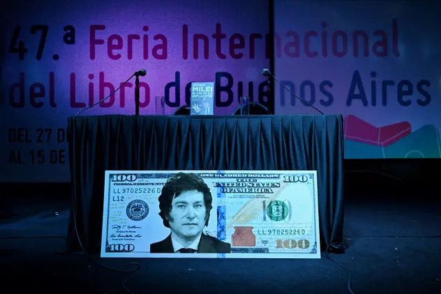 Un billete gigante de 100 dólares con la cara del diputado argentino Javier Milei es visto antes de la presentación de su libro "El fin de la inflación" en la Feria Internacional del Libro de Buenos Aires, el 14 de mayo de 2023. (Luis Robayo/AFP vía Getty Images)