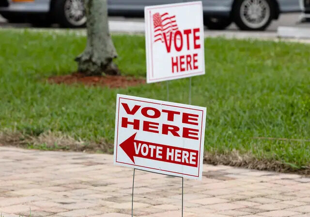 Carteles en el exterior de un colegio electoral durante las elecciones al Congreso del distrito 20 en Lauderhill, Florida, el 11 de enero de 2022. (Joe Raedle/Getty Images)