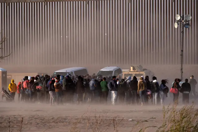Inmigrantes ilegales esperan a ser procesados por agentes fronterizos estadounidenses en la frontera entre Estados Unidos y México el 30 de marzo de 2023. (Guillermo Arias/AFP vía Getty Images)