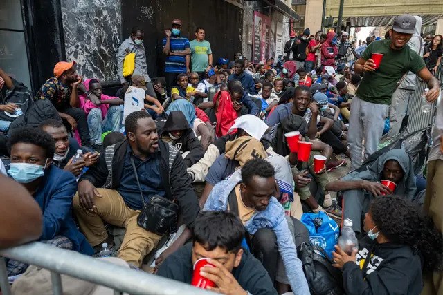 Decenas de inmigrantes ilegales recién llegados acampan frente al Hotel Roosevelt de Nueva York, convertido en centro de acogida, mientras intentan conseguir un alojamiento temporal en la ciudad de Nueva York el 1 de agosto de 2023. (Spencer Platt/Getty Images)