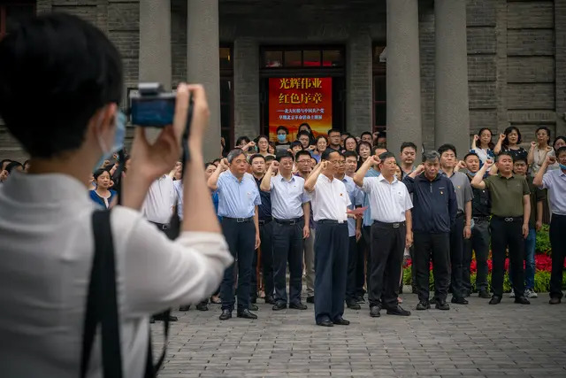 Visitantes prestan juramento ante una bandera comunista (no se ve) a la entrada del Edificio Rojo de la Universidad de Pekín, donde se ha instalado una nueva exposición como parte de las celebraciones del centenario del Partido Comunista de China, el 30 de junio de 2021 en Beijing, China. (Andrea Verdelli/Getty Images)