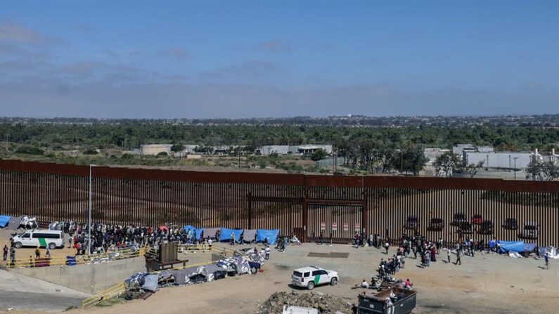 Migrantes permanecen junto al muro fronterizo, el 13 de septiembre de 2023, en la ciudad de Tijuana, en Baja California (México). EFE/Joebeth Terríquez