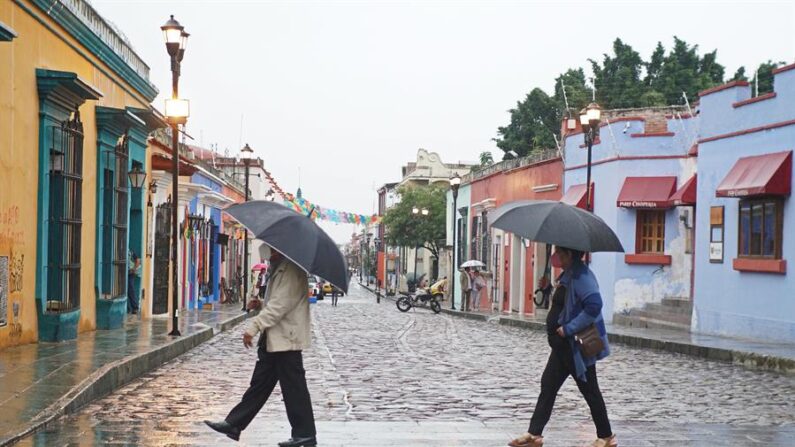 Personas se protegen de la lluvia en el estado de Oaxaca (México), en una fotografía de archivo. EFE/Daniel Ricardez