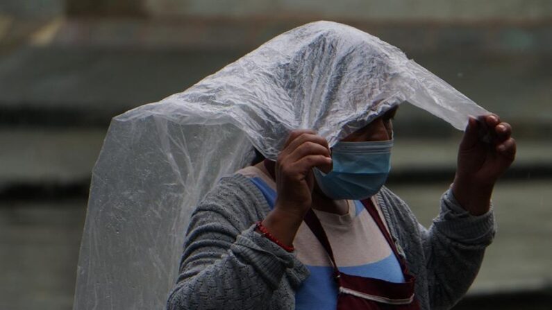 Una mujer se protege de la lluvia en el estado de Oaxaca, México. Fotografía de archivo. (EFE/Daniel Ricardez)