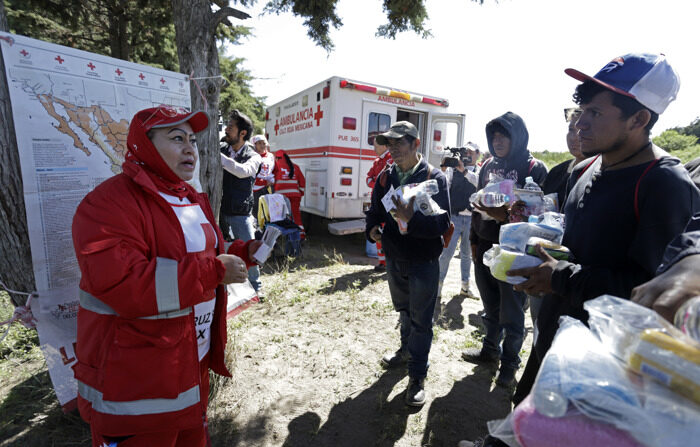 Una paramédica de la Cruz Roja, habla con migrantes centroamericanos a un costado de la vía del tren denominado "La Bestia", hoy en la comunidad de Jesús Nazareno, perteneciente al municipio de Ciudad Serdán Estado de Puebla, México. (EFE/ Hilda Ríos)
